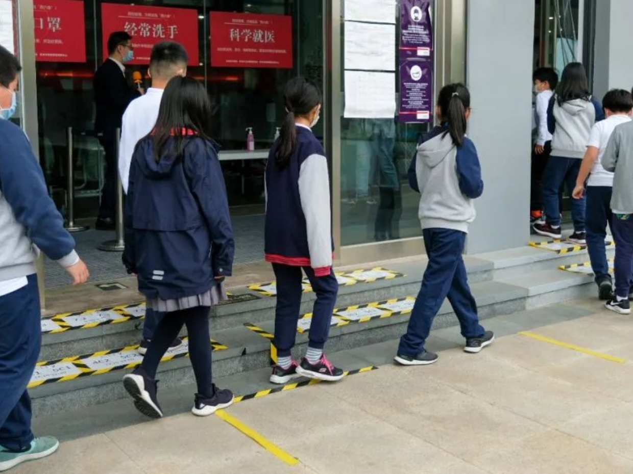 students in china wearing masks and in line for the school canteen