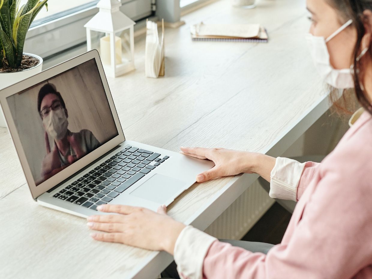 Woman having a video conference with a mask on